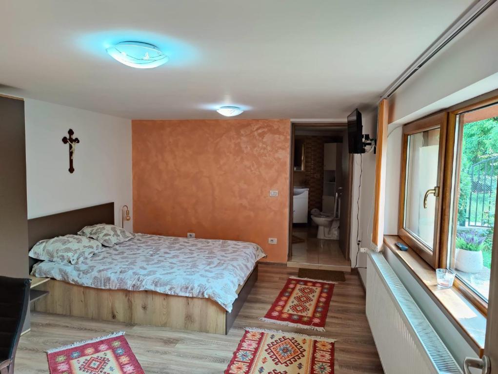 Schlafzimmer mit einem Bett und Blick auf ein Bad in der Unterkunft Casa Rustica in Borşa