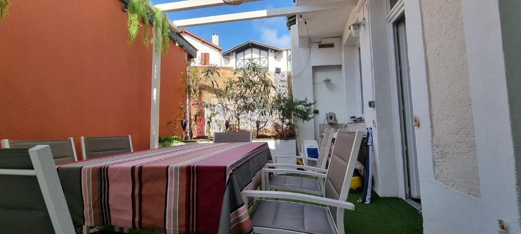 サン・ジャン・ド・リュズにあるBel appartement 3 ch. terrasse parkingの建物のバルコニーにテーブルと椅子