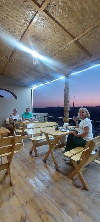 a woman sitting at a table in a restaurant at Guest House Art Postindoz in Khiva