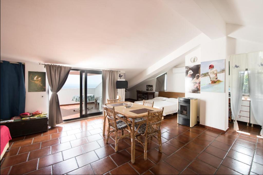 een woonkamer met een tafel en een kamer met een bed bij La Casa del Fotografo in Mortelle