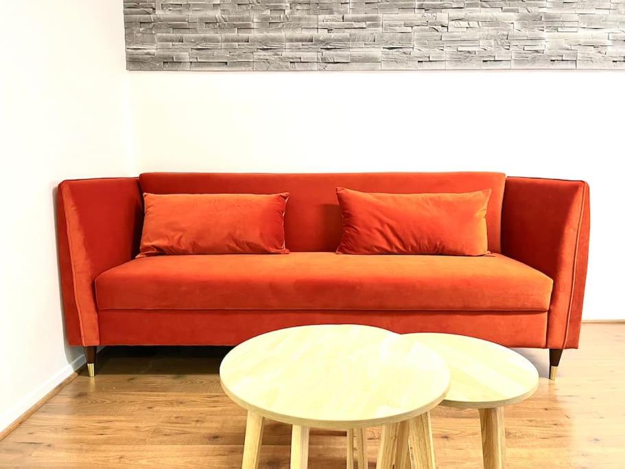 a red couch with two tables in a living room at Appartement • Paris/Disney • 1 Min Gare in Bussy-Saint-Georges