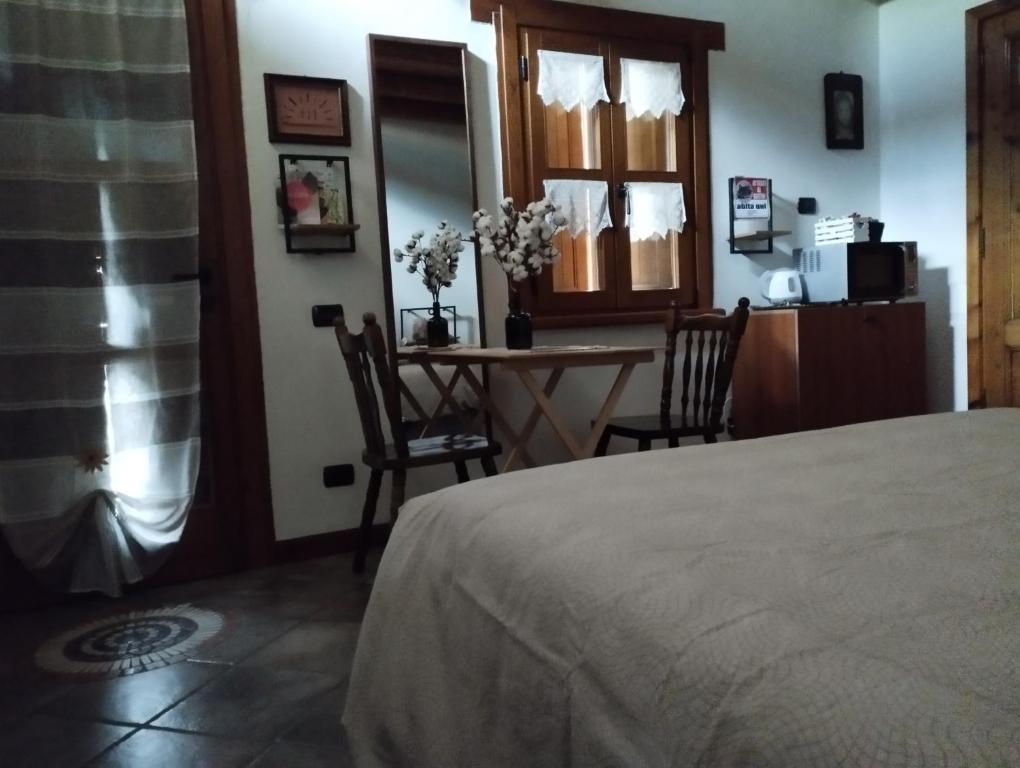 a bedroom with a bed and a table and chairs at ROSINA HOUSE e CHALET in Colico