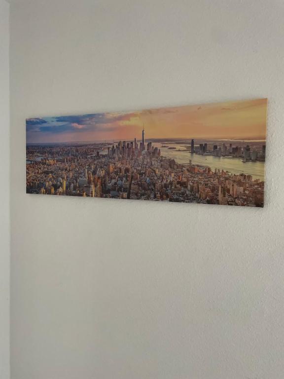 uma pintura de uma cidade numa parede em estrella24 LIVING ROOMS New York em Herne