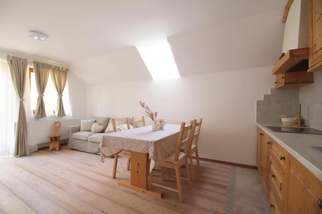 a kitchen and living room with a table and a couch at Apartments pr' Špeli in Bohinj
