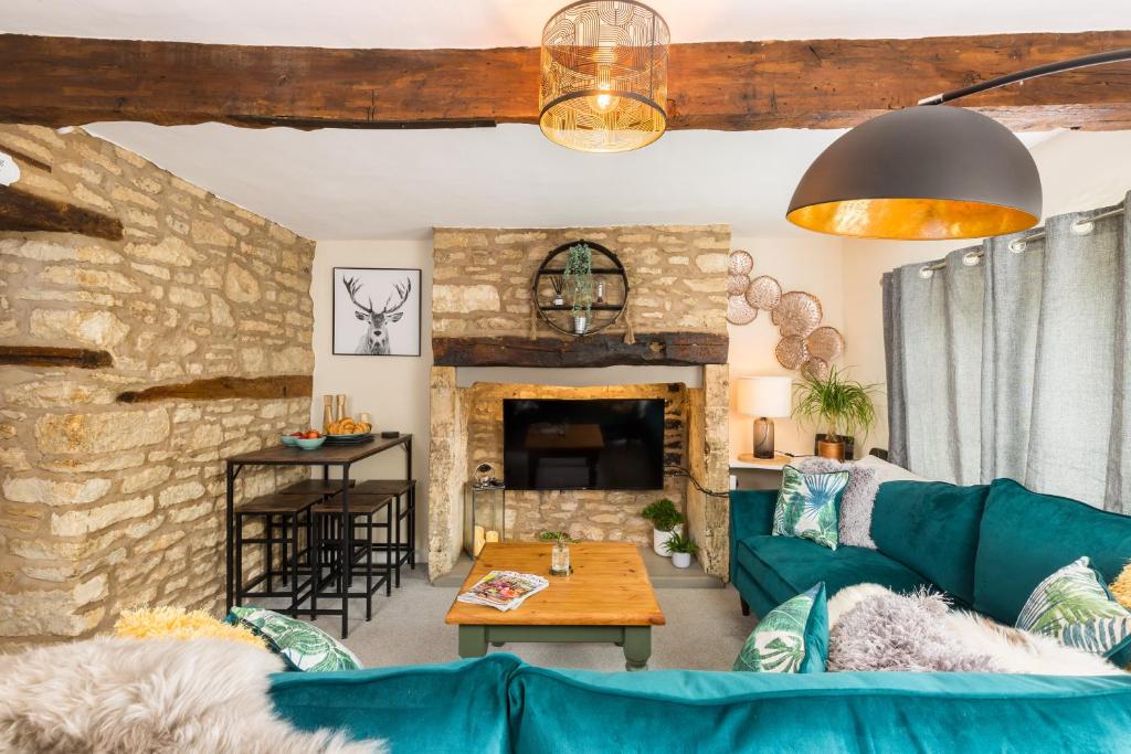 a living room with a blue couch and a stone wall at Why Not in Stow on the Wold