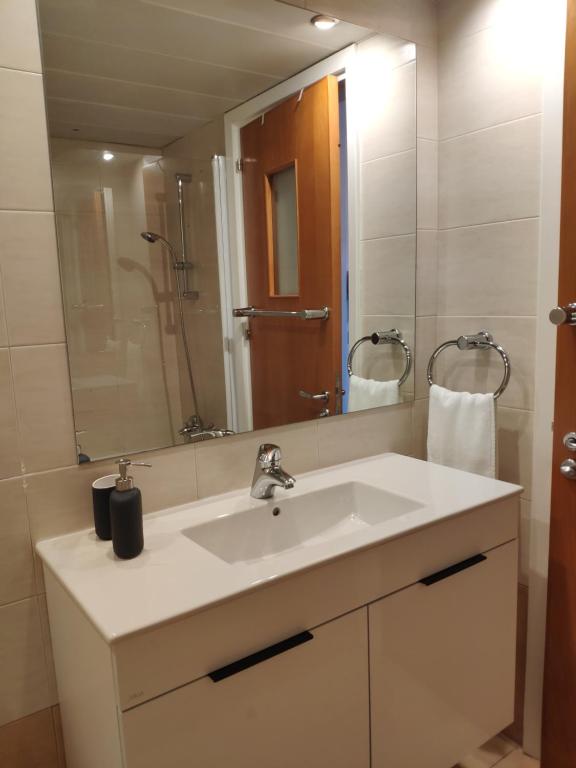 uma casa de banho com um lavatório branco e um espelho. em Ευ ζην Central / Ev zen central em Nicósia