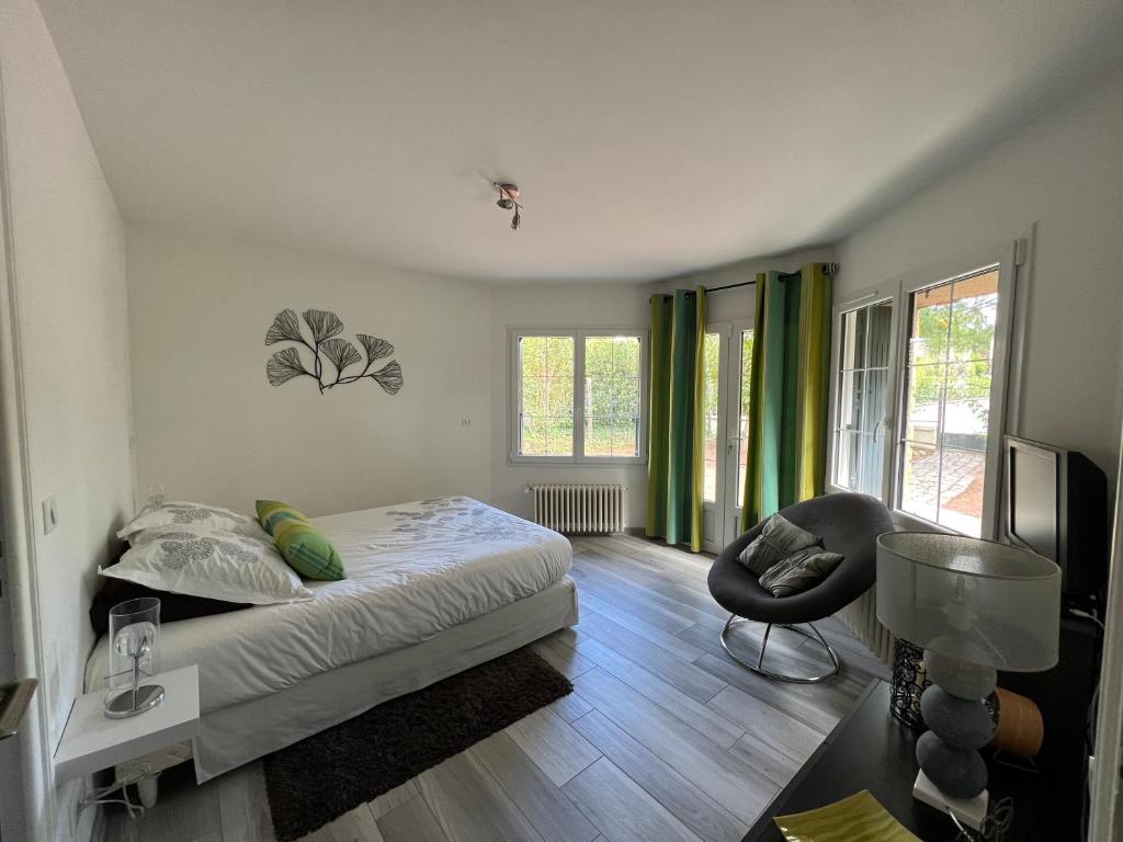 una camera da letto con un letto e una sedia di Chambre privée Chiberta a Chanas