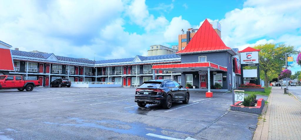 um carro estacionado num parque de estacionamento em frente a um edifício em Choice Inn by the falls em Cataratas do Niágara