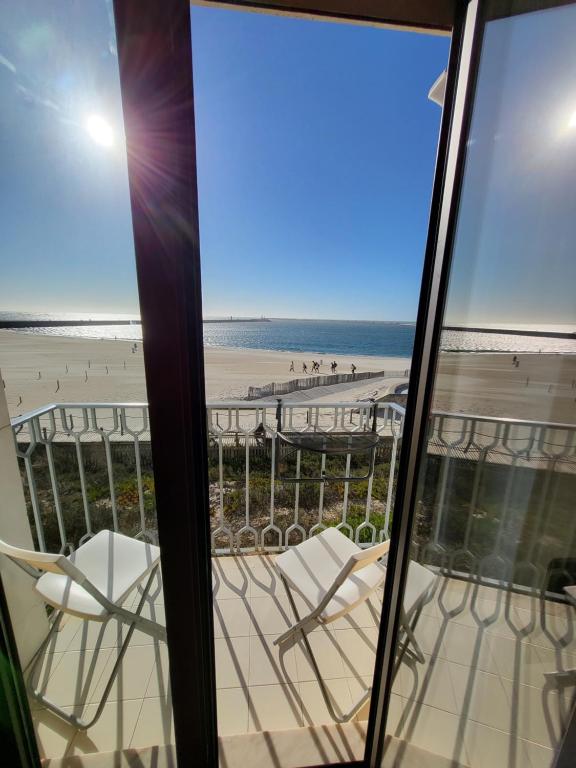 uma vista para a praia a partir da varanda de um condomínio em SonhosQrodopiam Praia da Barra em Praia da Barra