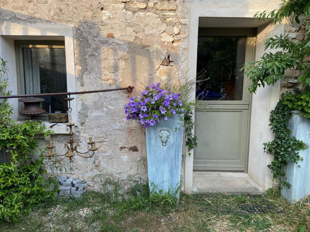 un bâtiment avec une porte et un vase de fleurs dans l'établissement Suite privée avec accès jardin en coeur de village, à Guerville