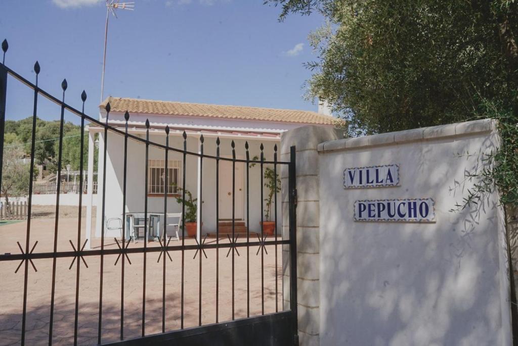 a fence with a sign on it in front of a building at Casa con piscina de agua salada Villa Pepucho 2 in Almodóvar del Río