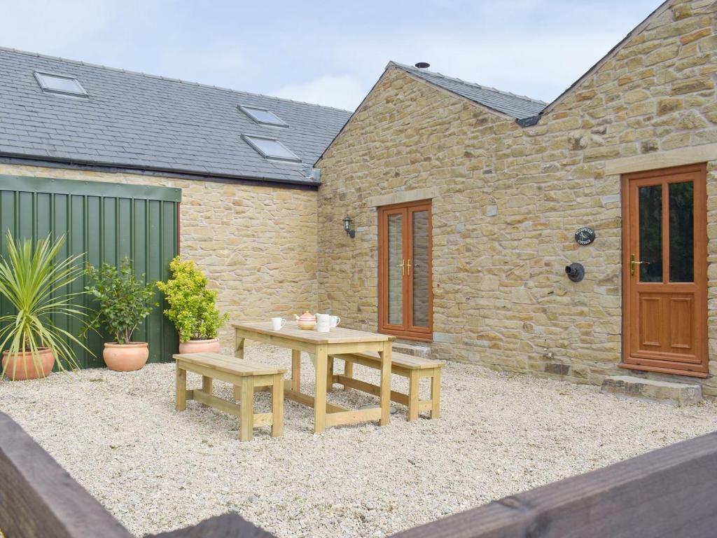 a patio with two benches and a table and a building at Woodpecker Cottage - Ukc3412 in Bolton by Bowland