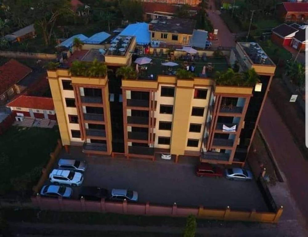 einen Blick über ein gelbes Gebäude mit geparkten Autos in der Unterkunft 2BHK Apartments in Kampala