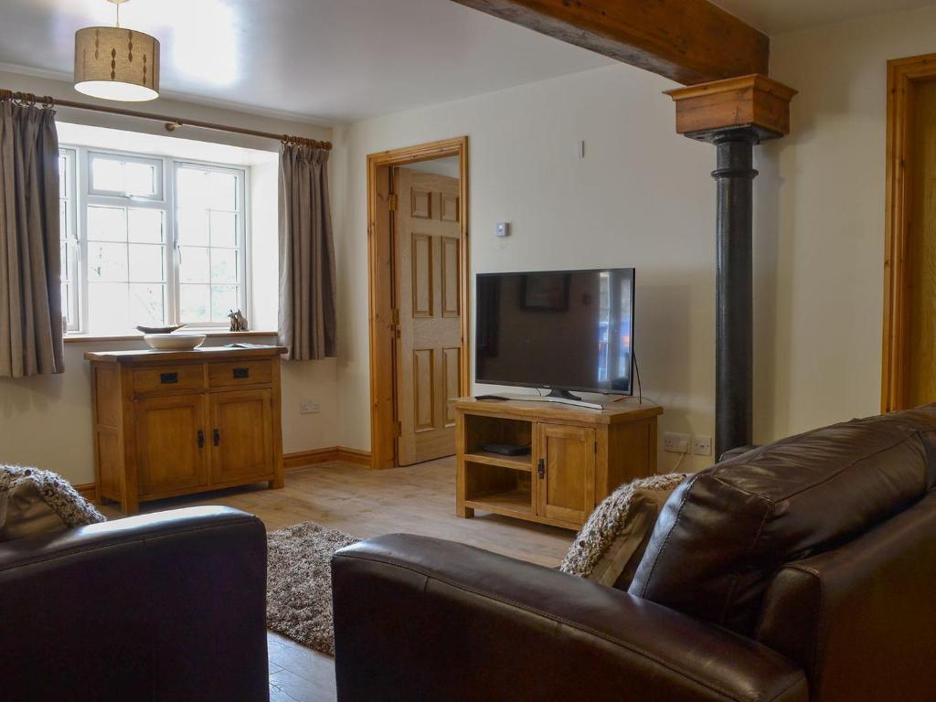 a living room with a couch and a flat screen tv at Snowdon - Uk6627 in Pen-y-groes