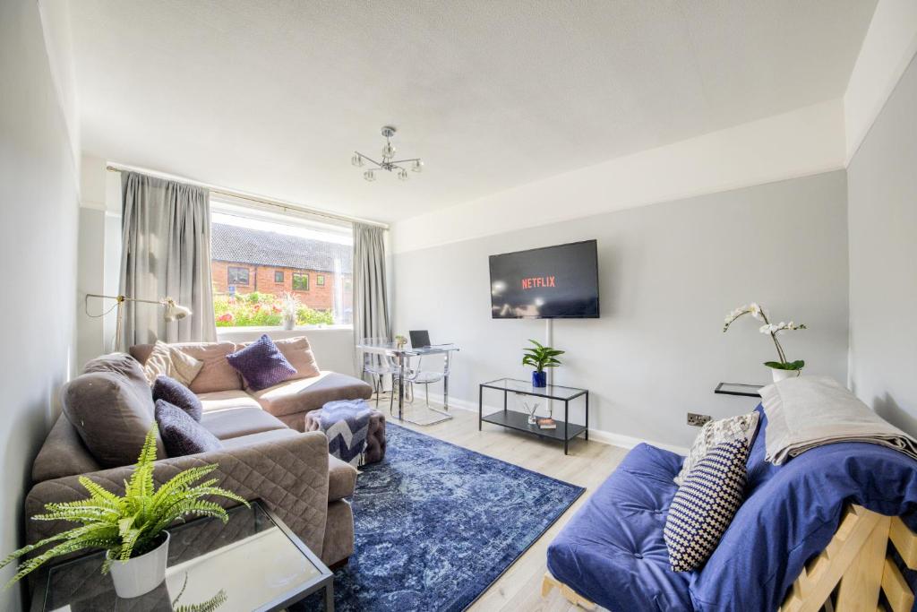 a living room with a couch and a tv at Town Centre Apartment in Leamington Spa
