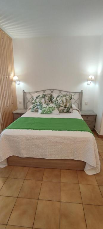 ein Schlafzimmer mit einem großen Bett mit grüner Bettwäsche in der Unterkunft Apartamento en icod de Los Vinos, playa San Marcos in San Marcos