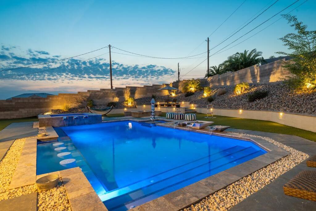 a swimming pool in a yard with a stone wall at Heated Pool & Spa - Winterhavens Oasis in Lake Havasu City