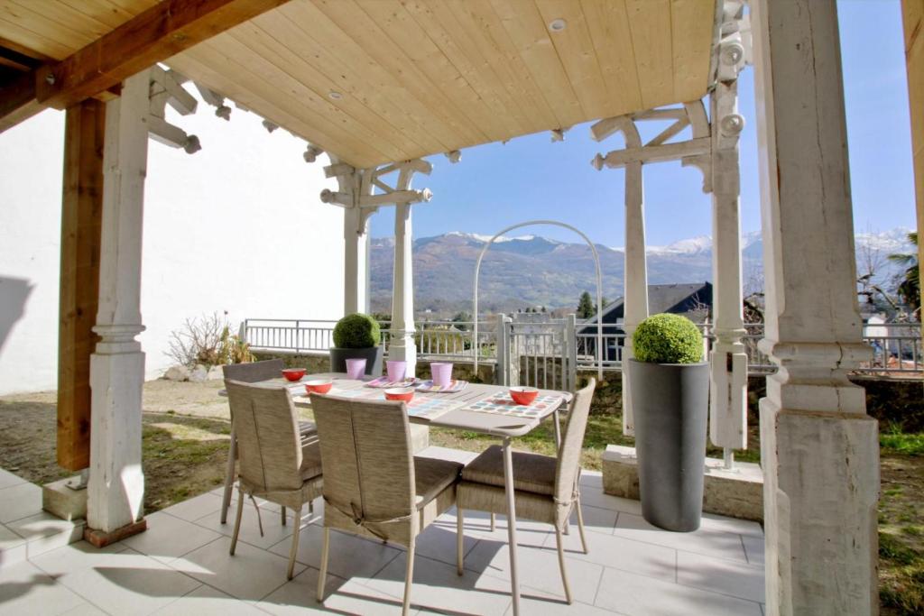 a patio with a table and chairs under a pergola at Maison Planté a1 in Argelès-Gazost