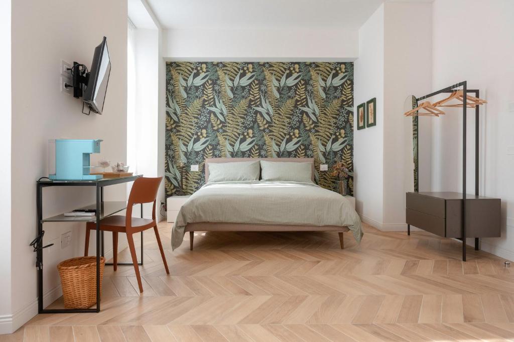 a bedroom with a bed and a desk with a chair at CASA Room Apartments Diaz 8 in Trieste