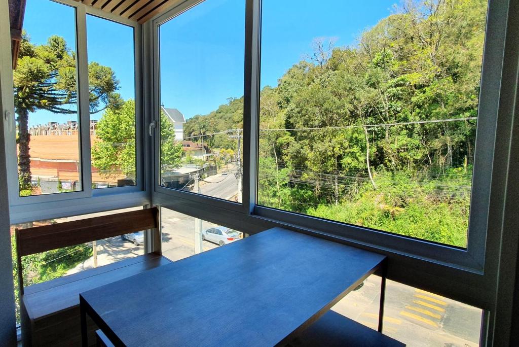 a table in a room with windows at Apto Encantador Próximo ao Centro de Gramado in Gramado