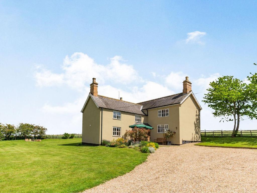 an old house with a grassy field in front of it at Limber Wold House in Great Limber