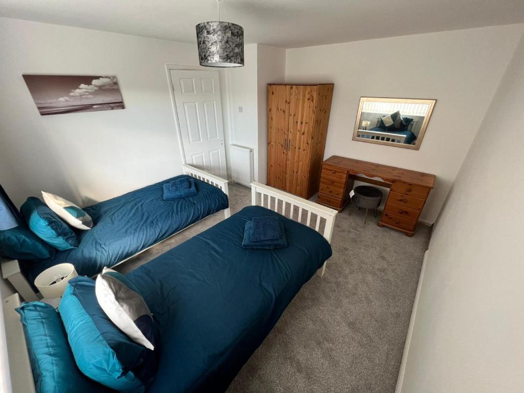 um pequeno quarto com 2 camas e um sofá em Seaside 2 bedroom house with large garden em Rhyl