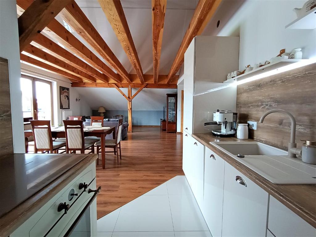 a kitchen with white cabinets and a table with chairs at Barytowy apartament in Tarnowskie Góry