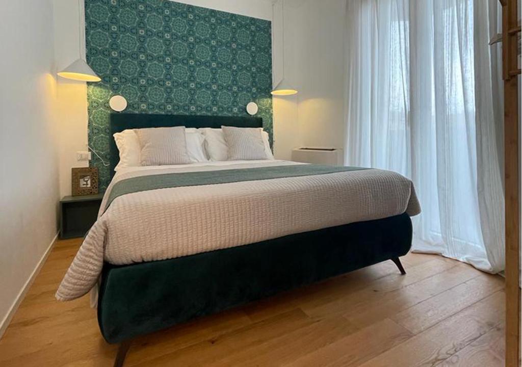 1 dormitorio con 1 cama grande y cabecero verde en Tecnopolo Fiera Suite, en Bolonia