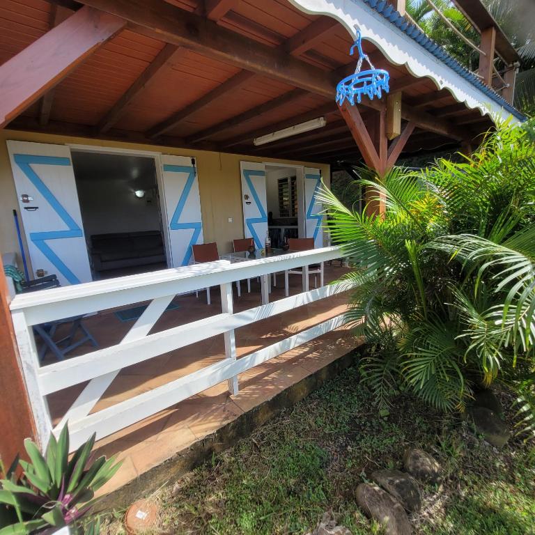 une terrasse couverte d'une maison avec une clôture blanche dans l'établissement Studio a sofaia, à Sainte-Rose