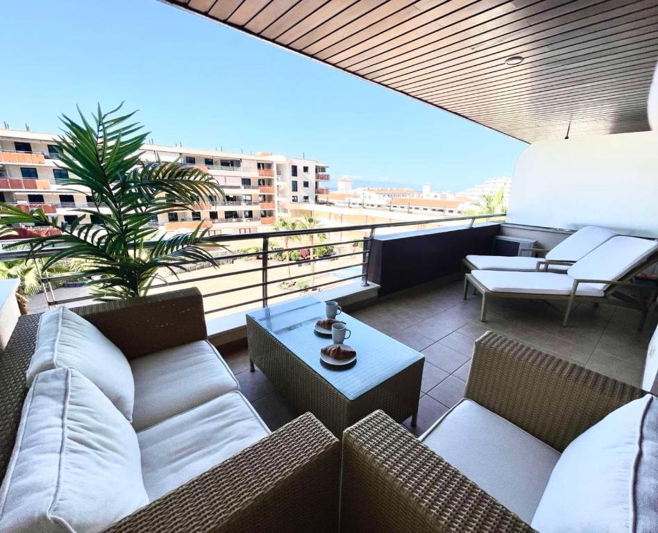 a balcony with couches and a coffee table on a building at Casa Lea Los Gigantes in Puerto de Santiago