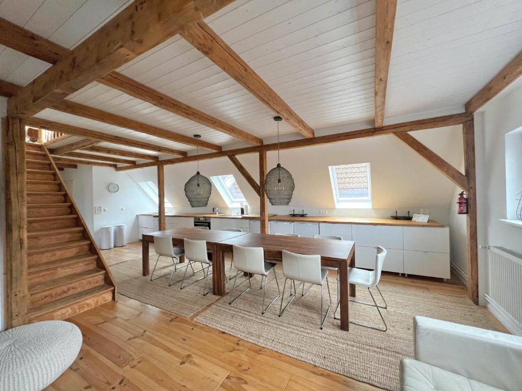 a kitchen and dining room with a wooden table and chairs at Historisches Amtshaus: BelVue in Fehmarn