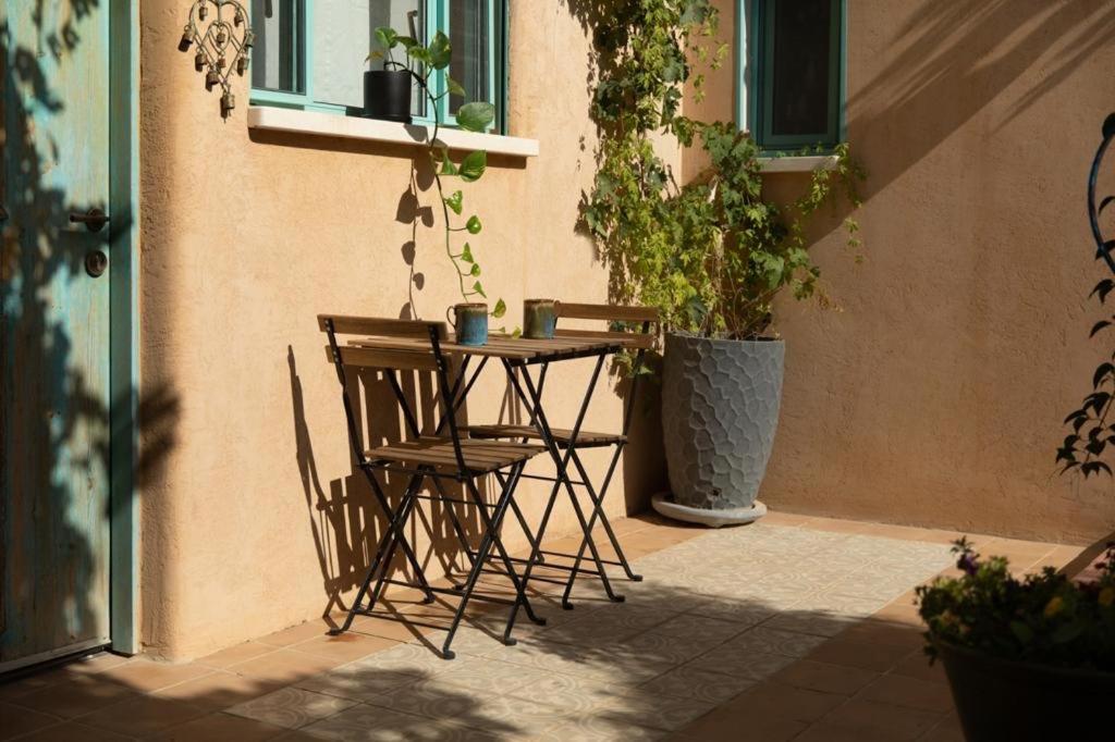 a patio with a table and chairs and potted plants at Simply with love in Avtalyon