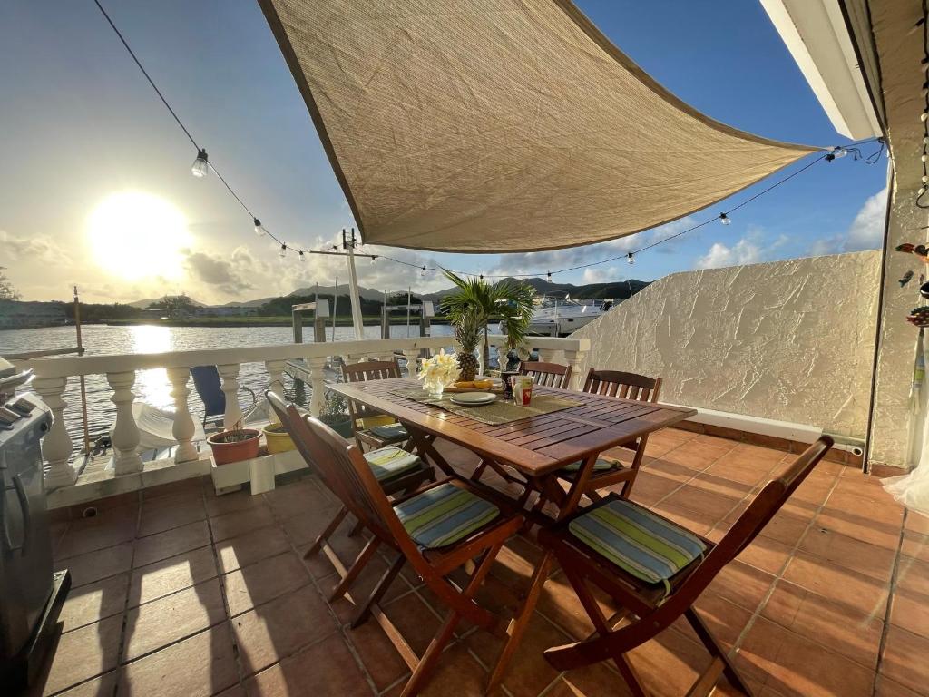 a table and chairs on the deck of a boat at Sunny Villa in the Marina - Excellent Water Views in Jolly Harbour