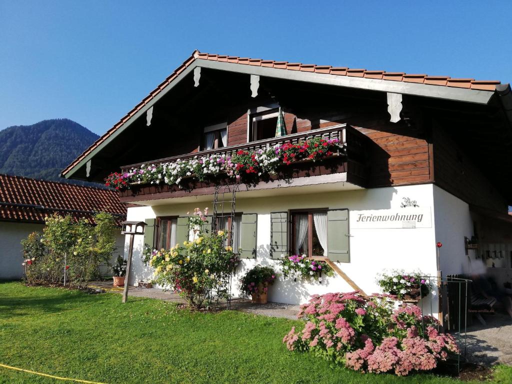 a white house with flowers on the balcony at Ferienwohnung Emilia mit Bergblick (Osten) in Ruhpolding