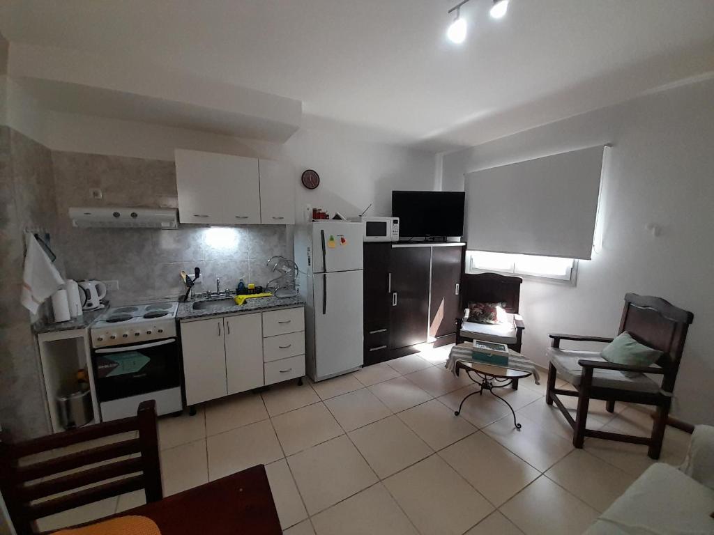 a kitchen with white appliances and a table in a room at Caseros Centro in San Juan