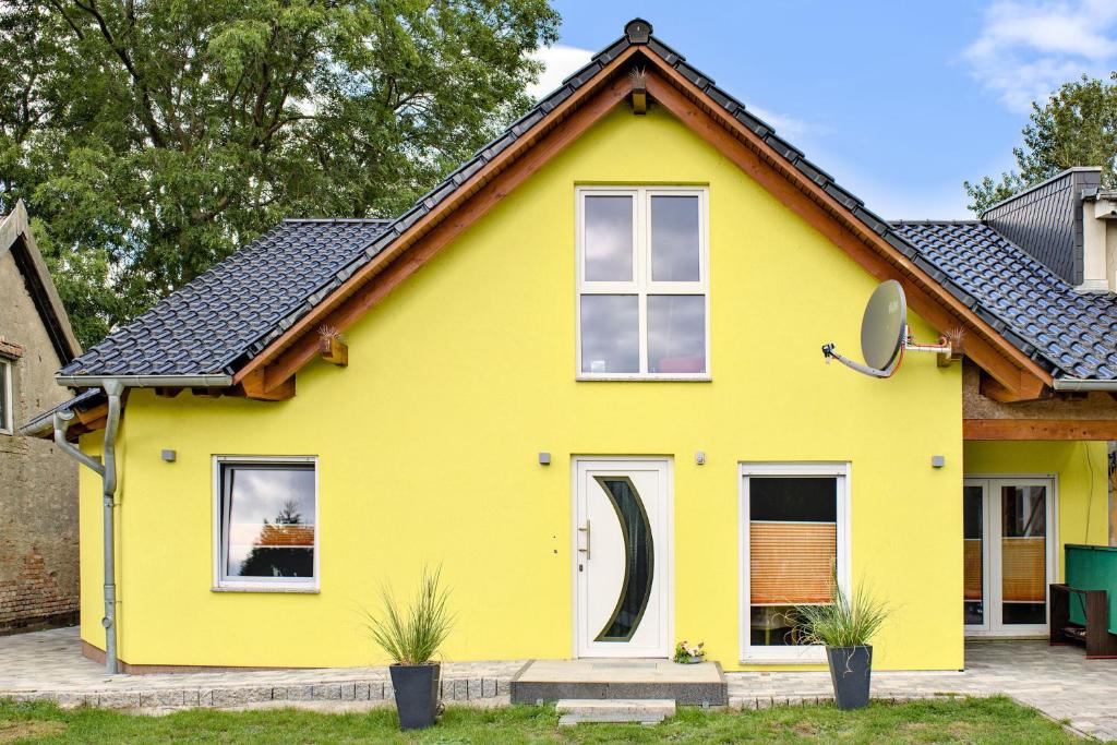 a yellow house with a black roof at Fewo Usedom Peene Idyll in Wolgast