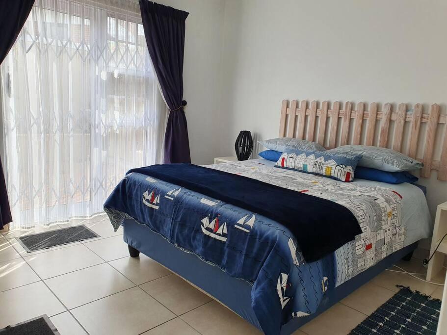 1 dormitorio con 1 cama con edredón azul en 29 Jeffs Place, en Yzerfontein