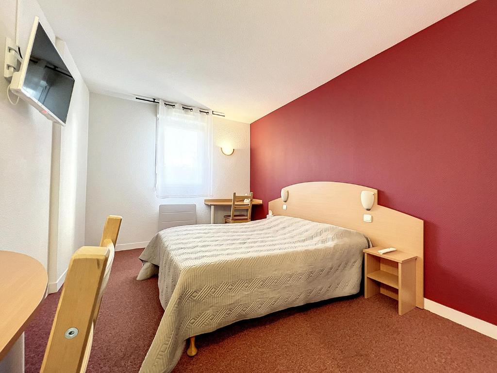 - une chambre avec un lit et un mur rouge dans l'établissement ValHôtel - Hôtel-Résidence Châteaufort, à Châteaufort