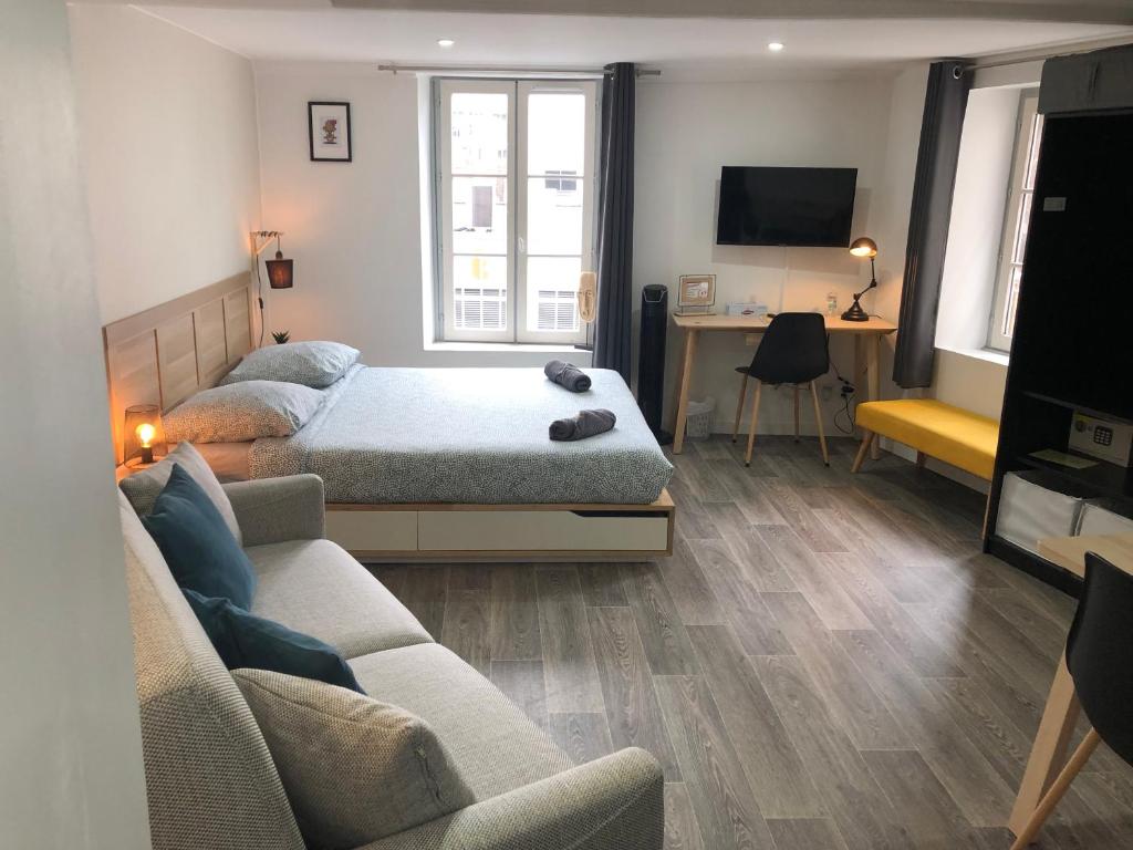 a living room with two beds and a couch at Jolis Appartements au coeur de Clermont Ferrand - Proche Jaude - WIFI et NETFLIX in Clermont-Ferrand
