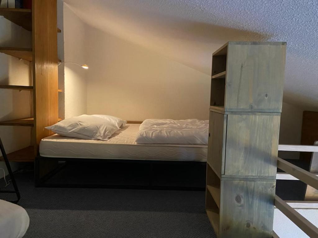 - une chambre avec un lit et une étagère dans l'établissement VALFREJUS résidence chaviere, à Modane