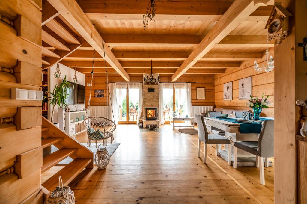 a kitchen with wooden ceilings and a dining room at Villa Carmen in Korzkiew