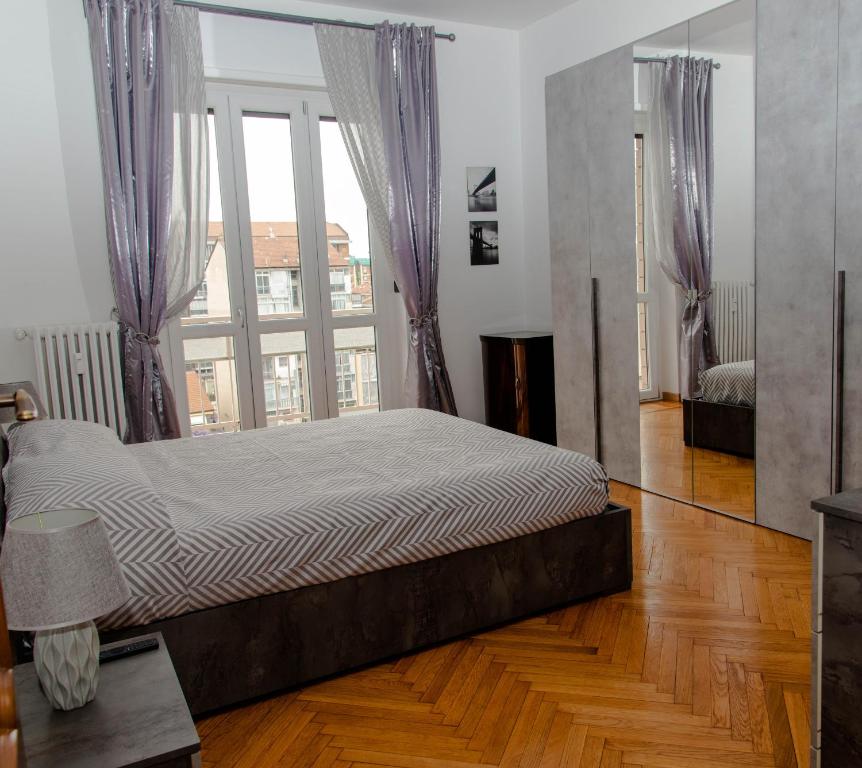 トリノにあるA casa di Ivy e Babyの大きな窓付きの客室の大型ベッド1台分です。