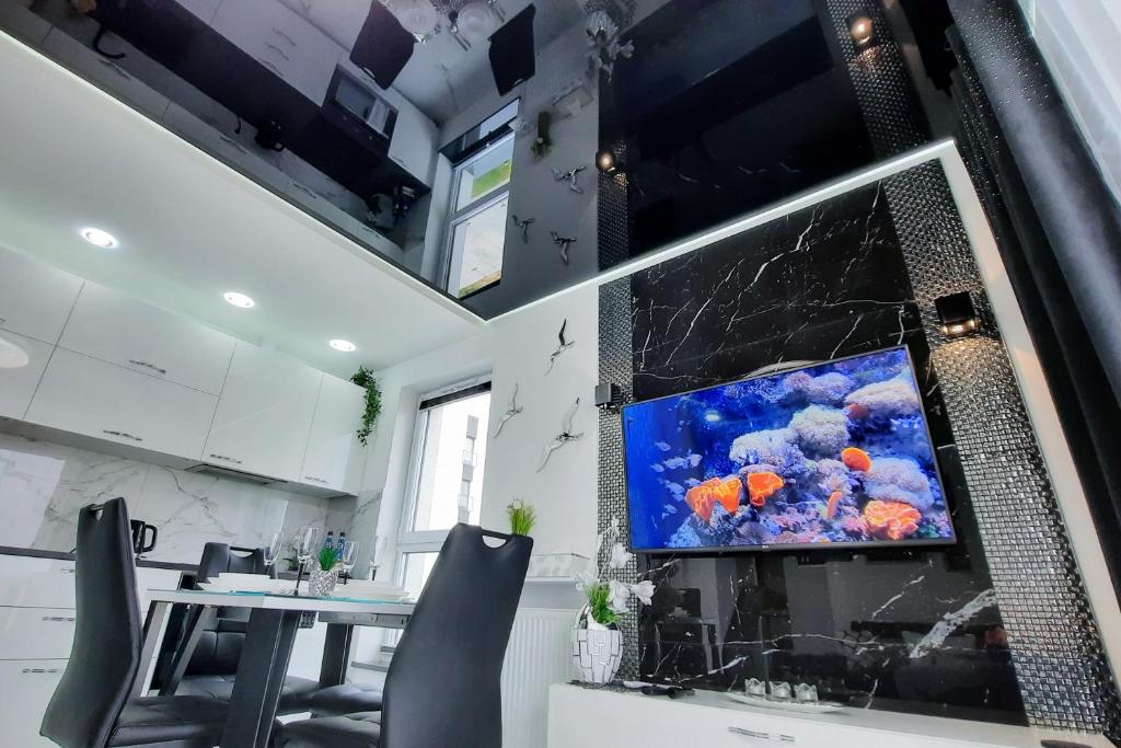 ein Esszimmer mit einem Großbild-TV an der Wand in der Unterkunft Apartament 10 Glamour Aquapark Reda in Reda