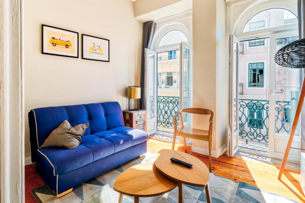 a living room with a blue couch and a table at THE LEMON TREE in Lisbon