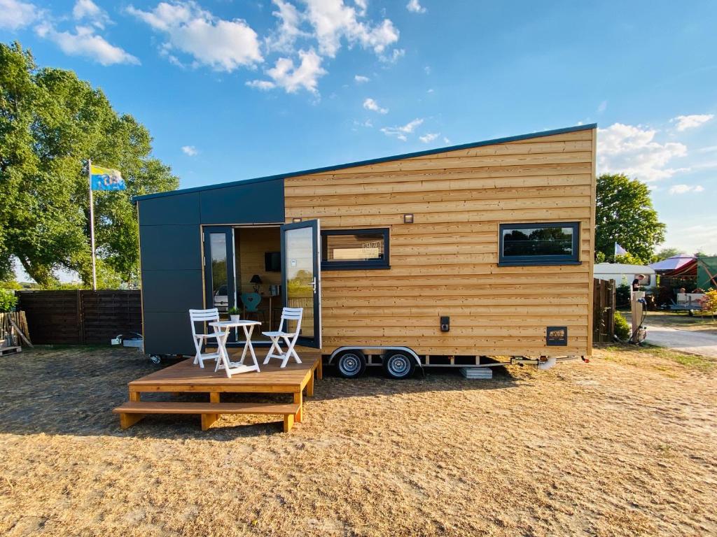 una casa pequeña con mesa y 2 sillas en WiNZiG Wohnen Tiny House SKADI am Weserstrand, en Elsfleth