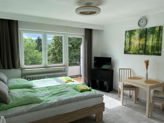 een slaapkamer met een bed, een tafel en een raam bij Ruhiges und klimatisiertes Apartment in Stuttgart