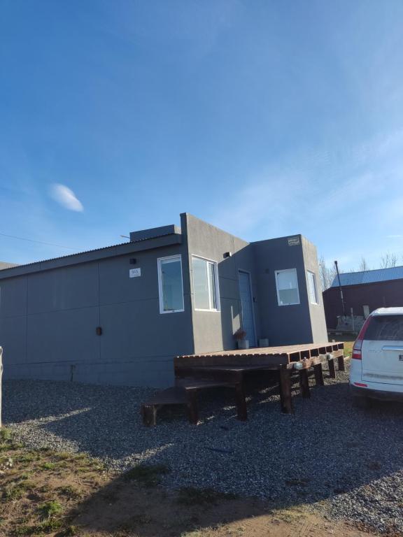 a house with a picnic table and a building at Azules 2721 in El Calafate