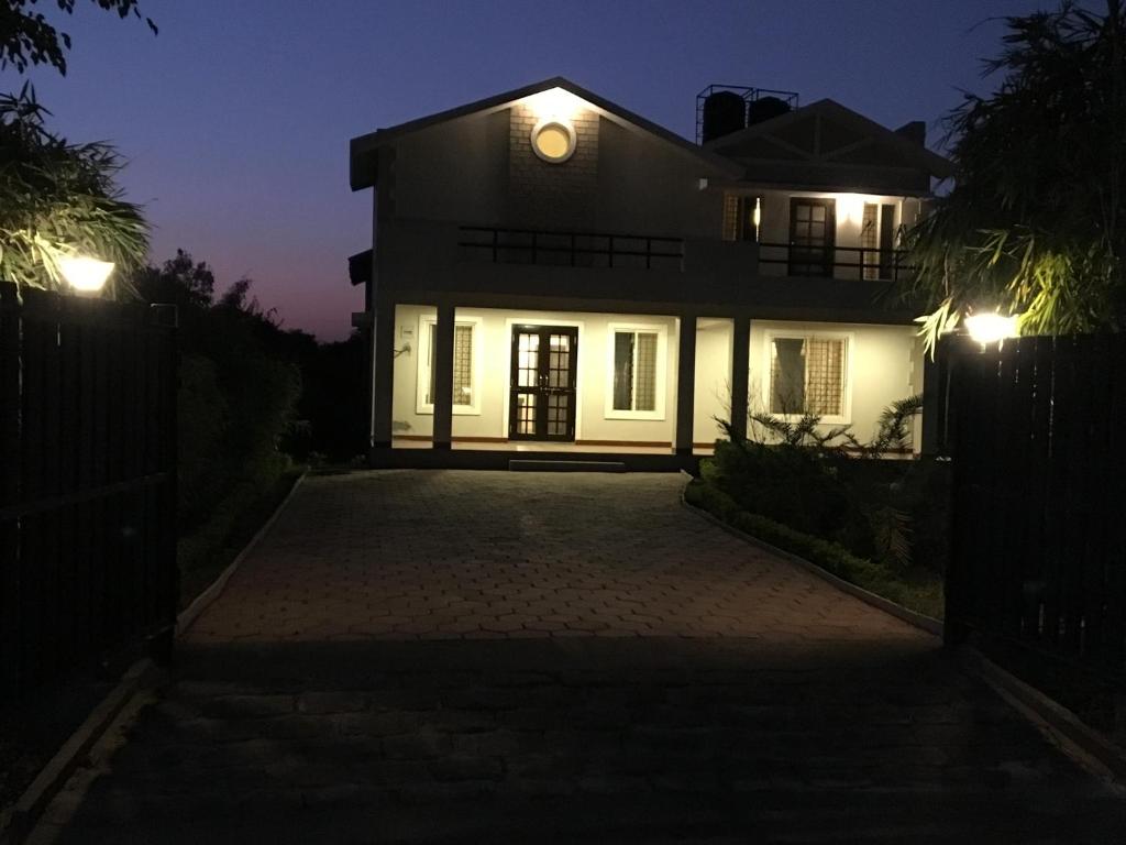 a house with a clock on the top of it at night at Celestial Resorts, Retreat in Nature in Phanda