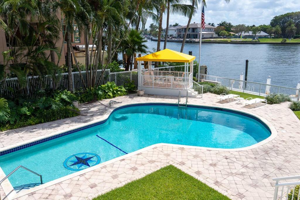 a swimming pool next to a body of water at Studio- Sleep 2,Pool, Parking,5min walk to Beach -3 in Fort Lauderdale