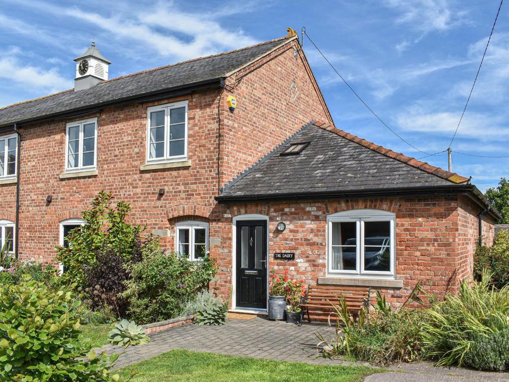 an old brick house with a clock tower on top at The Dairy At Brook House Farm-uk40631 in Church Minshull